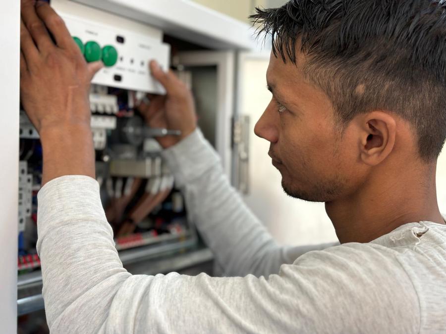 Technician wiring an industrial control panel